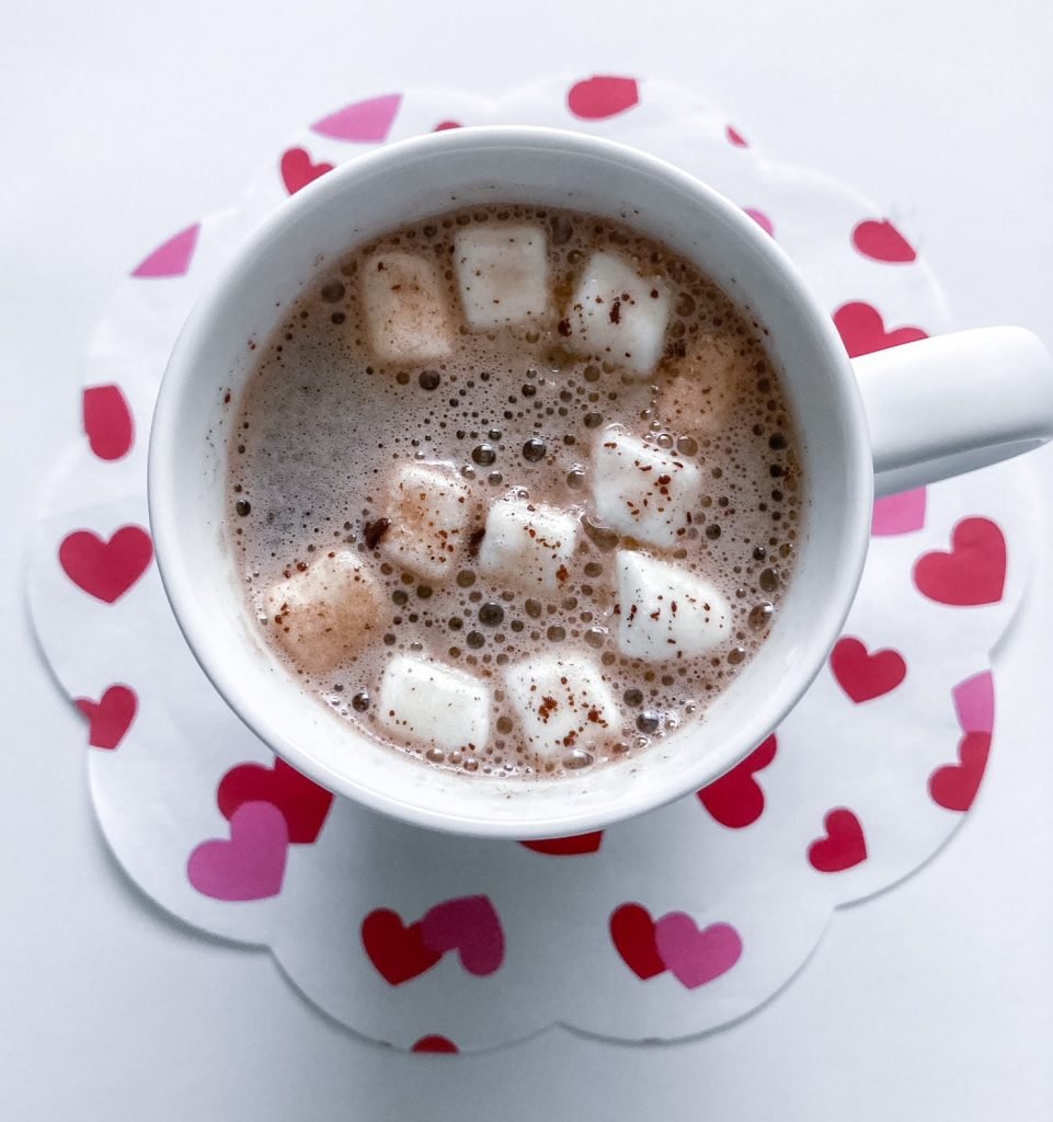 Hot cup of milk with chocolate bomb with marshmallows